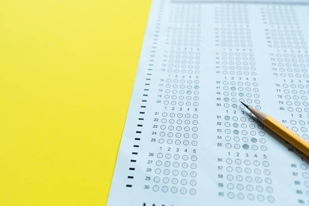 istock close up pencil  on answer sheets with yellow background, education concept 2231744362