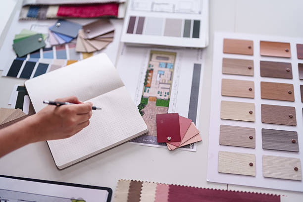 istock Architect plans modern home interior design project selecting materials from color palettes and fabric samples on desk 2231757668