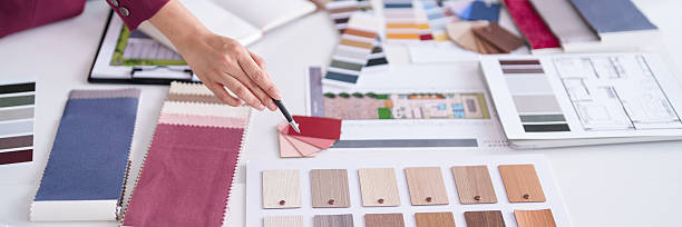 istock Professional Interior Designer Hand Selects Fabric Wood Material Samples Architectural Plans Home Renovation Planning 2231757673