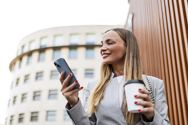 istock Successful young woman relaxing with coffee and mobile during work break 2231764301
