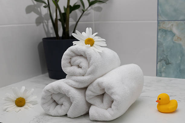 istock Relaxing Spa Setup With Rolled Towels, Flowers, and a Rubber Duck 2231766293