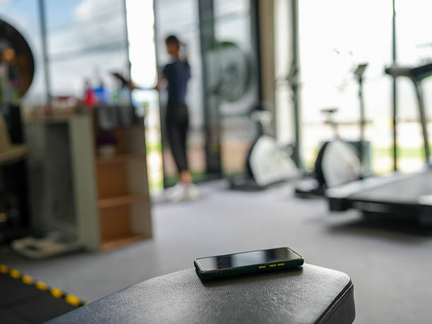 istock Smartphone rests on gym bench, with exercise equipment in background. scene captures modern fitness environment, emphasizing health and activity 2231774687