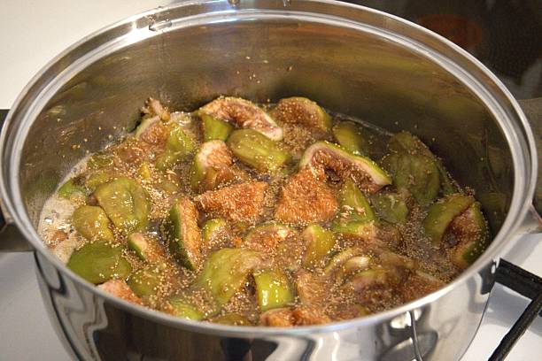 Fig jam cooking in pot on stove, close up