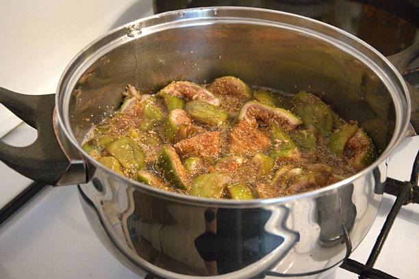 Fig jam cooking in pot on stove, close up