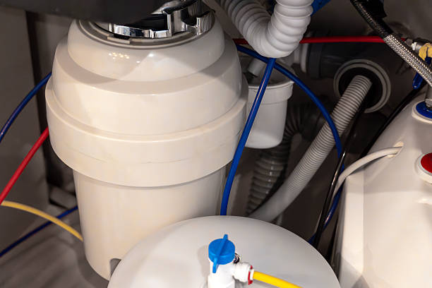 istock Close-up of a kitchen garbage disposal system installed under the sink, with connected pipes and colored hoses 2231779959