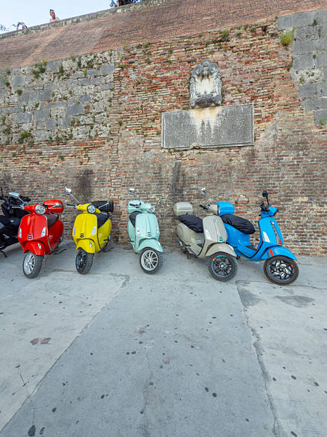 istock Colorful Scooters Parked Along Brick Wall 2231786028