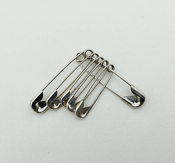istock Cluster of Silver Metallic Safety Pins on White Background 2231787042