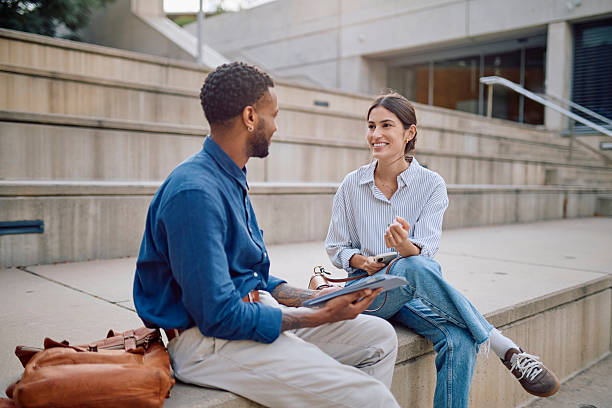 istock Two Young Professionals Collaborating on a Project Outdoors 2231790036