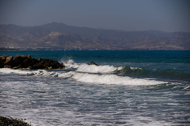 Dramatic seascape showing powerful Mediterranean waves crashing on sharp coastal rocks of Cyprus island.