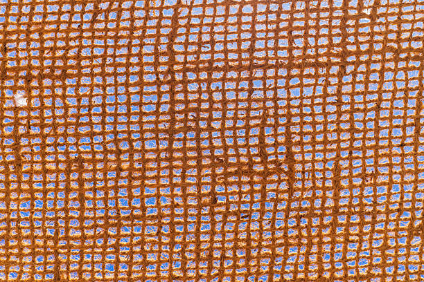 istock Abstract texture background of a rustic brown jute hessian fabric, with a woven grid pattern against a bright blue sky. 2231790619