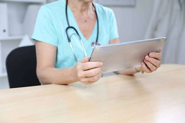 istock Experienced Female Doctor Checking Patient Data on Tablet 2231791871