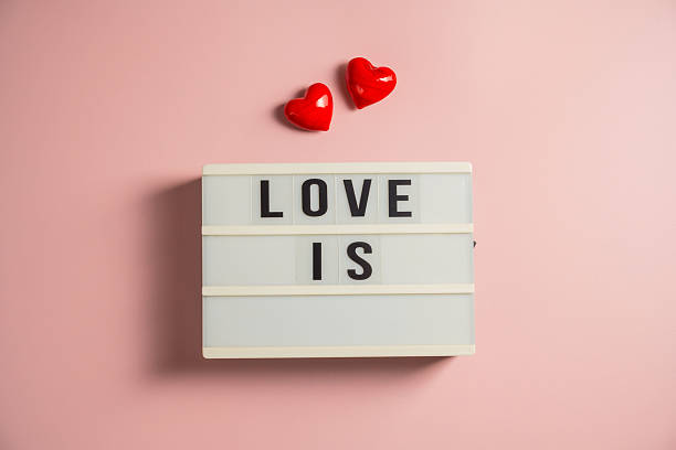 istock Word love with a red hearts over pink background 2231792413