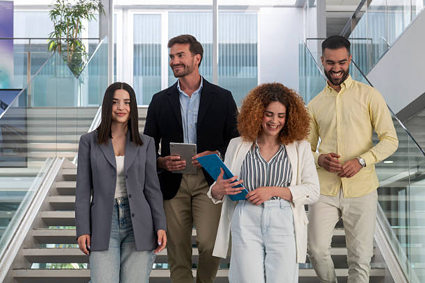 istock Businesspeople walking downstairs in modern office 2231796591