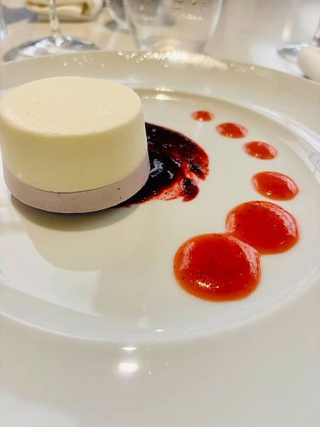 istock Refined dessert consisting of a two-tone mousse, with a light layer and a purple layer, served on a base of mixed berry sauce. 2231797148