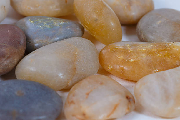 pebbles. clean white brown black pebbles isolated. the pebbles are on white or brown sand. small and large are visible