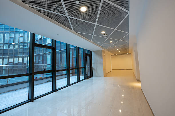 A stylish, modern office corridor with large windows and minimalist design elements, perfect for corporate or commercial use.