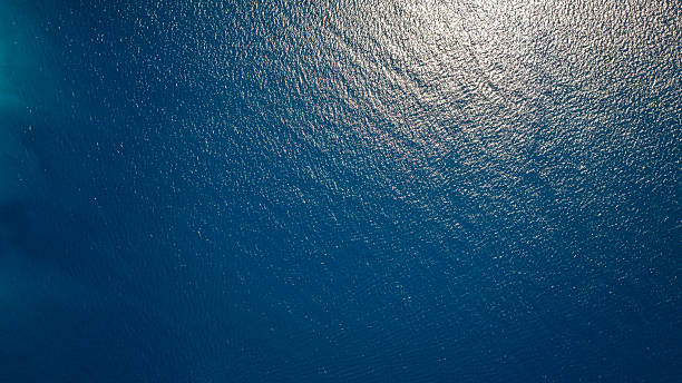 istock Sunlight reflecting on calm dark blue Aegean sea in Greece 2231803285