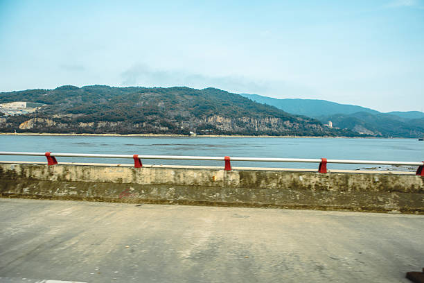 Falling preventive metal railing at water reservior barrage with background of greenery environmental of hillside. Nature and outdoor photo.