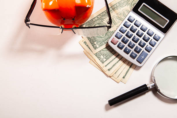calculator, magnifying glass and dollars