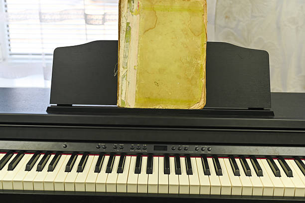 Old music book standing on electronic piano, blending tradition with modern technology. old music book is bridge between classic and contemporary melodies. concept