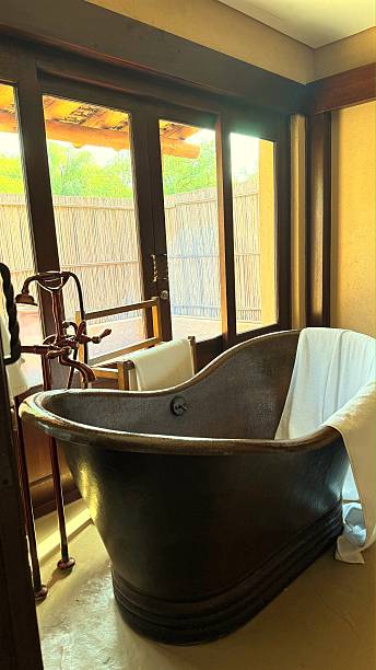 istock Sunlight filtering through window, copper bathtub adorned with white towels, radiating relaxation and luxury in sophisticated bathroom interior design 2231811079