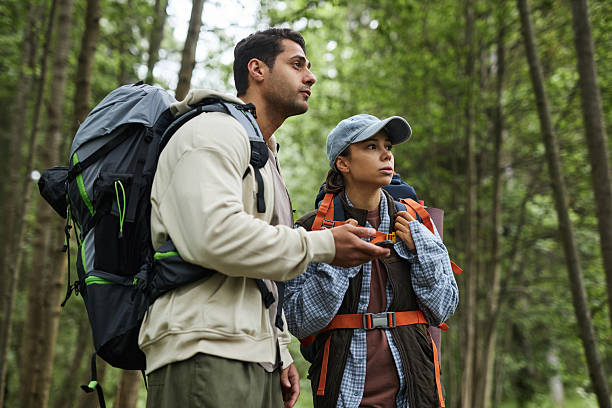 istock Young Adult Multiethnic Couple Navigating Forest Trail with Gps Device 2231819117