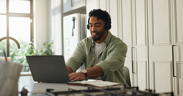 istock Man, headset and laptop in kitchen for remote work, typing and advice for customer care call center. Technology, freelance help desk and consultant or virtual assistant for telecom support in home 2231821564
