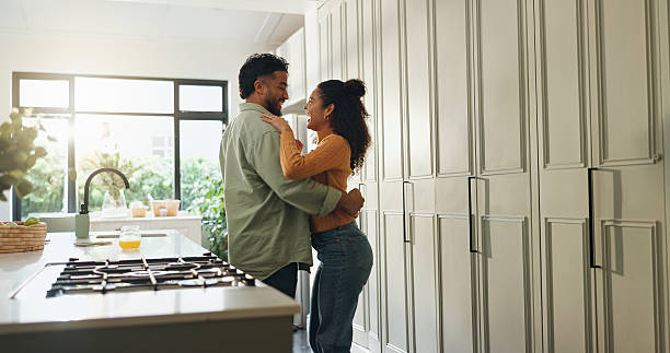 istock Laughing, couple and hug in kitchen, love or bonding on break in house, commitment or relationship. Happy, man and embrace with woman in home, affection and romance in apartment, care or marriage 2231821597