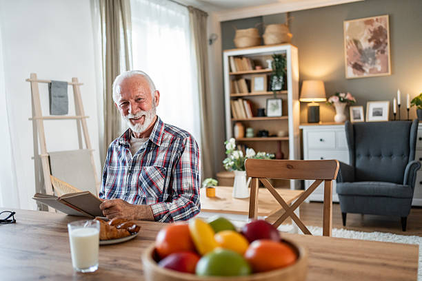istock Senior man enjoying a relaxing morning with book and breakfast 2231824466