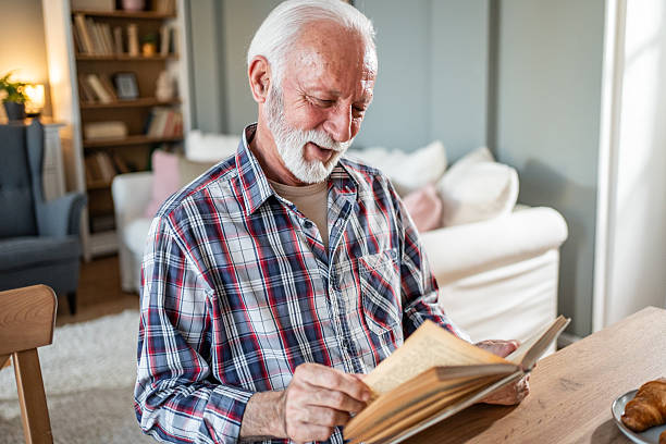 istock Senior man enjoying a book and breakfast at home 2231826271