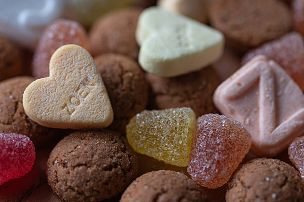 Close-up of traditional Dutch Sinterklaas (Saint Nicholas) candy mix, with spiced cookies (kruidnoten) and a colourful heart-shaped sweet with the word 'ZOEN' (kiss). A festive treat enjoyed in the Netherlands during the holiday season.
