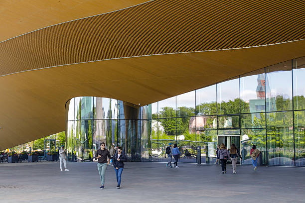 Uppsala, Sweden – November 17, 2023: A shot of the back of an architecturally impressive building, with lush greenery in the foreground