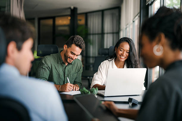 istock Multiracial colleagues discussing startup project and smiling during workday in office interior 2231828305