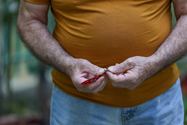 The 75 -year -old Iranian old man is choosing medication and taking pills, he is in his living garden, the concept of medical treatment and treatment.