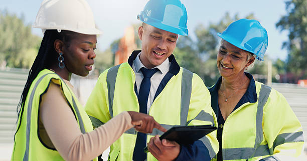 istock Man, architect and team with tablet at construction site with talk, point and infrastructure development. People, technician or engineer with smile, app and feedback for property expansion project 2231836029