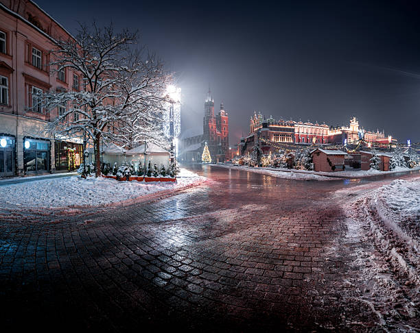Krakow Market Square in winter. View of St. Mary's Basilica and the Cloth Hall in the old town.\nEuropean City, Poland.