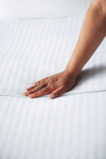 istock Hand Placing On Smooth Striped White Fabric Surface in Indoor Setting 2231841173