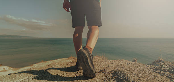 istock mans walk on the beach, closeup 2231843301