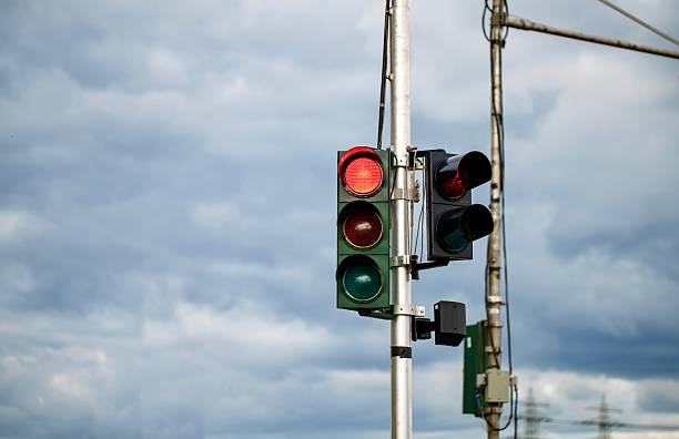 istock Red Traffic Light Against Cloudy Sky – Concept of Stop and Decision 2231858341