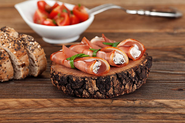 Pork loin rolls stuffed with cream cheese and olives on wooden background horizontal shot