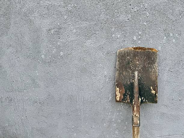 istock Old rusty shovel against concrete wall 2231863120