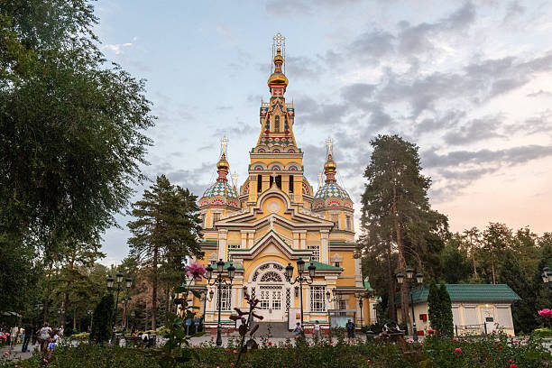 Stunning view of the Ascension Cathedral, a historic wooden Orthodox church in Kazakhstan, framed by a bright blue sky.