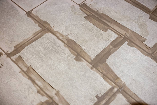 istock freshly applied grout filling the gaps between large light grey floor tiles 2231868836