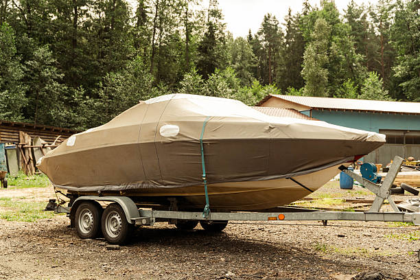 istock Covered motorboat standing on a trailer in a forest area 2231869067