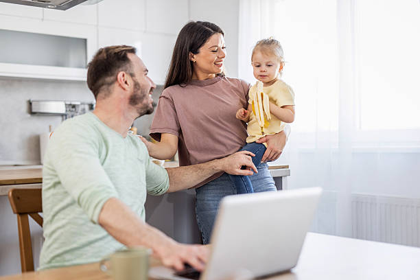 istock Happy family using laptop in kitchen while eating banana 2231872118