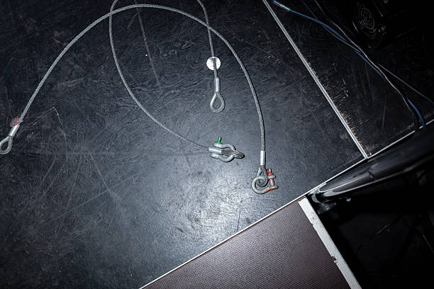 Stage rigging cables and hardware equipment on scratched floor surface