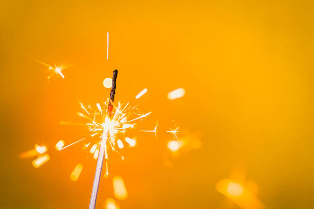 Textured abstract backgrounds. Golden background with lit sparkler. stock photo