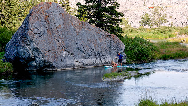 istock Adult siblings SUP board on mountain river 2231879676
