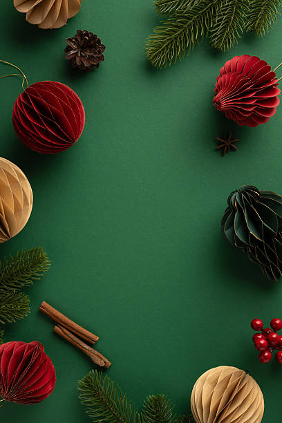 istock Top vertical view of Christmas decorations featuring ornaments, pine branches, cinnamon sticks, and berries 2231879836