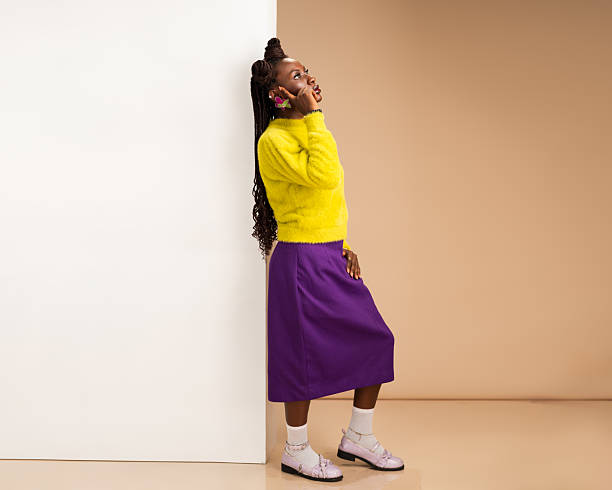 istock African woman leaning against wall while talking on phone 2231887256